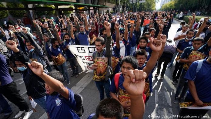 Protesters raise their hands in the air