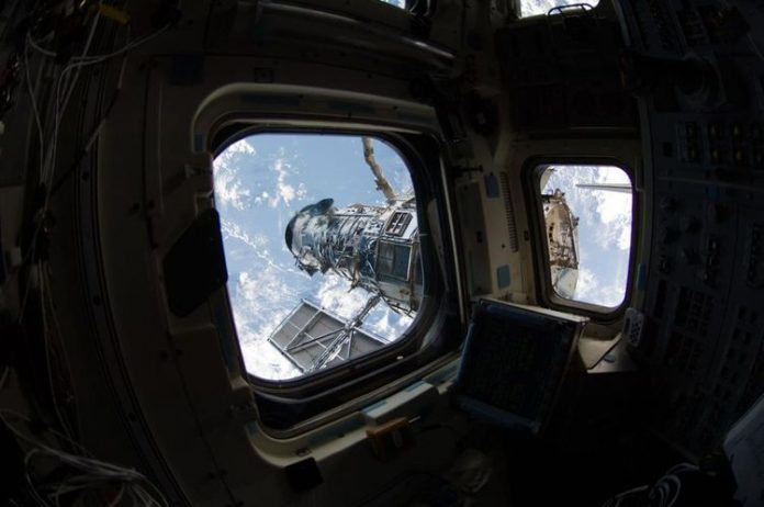 Hubble seen from the window of Atlantis in 2009.